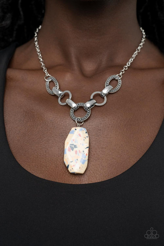 Mystical Mineral - Multi Stone Necklaces featuring a colorful multicolored terrazzo finish, a faceted faux stone swings from a row of studded silver rings, flat silver hoops, and oversized silver fittings, creating an earthy pendant below the collar. Features an adjustable clasp closure.  Sold as one individual necklace. Includes one pair of matching earrings.