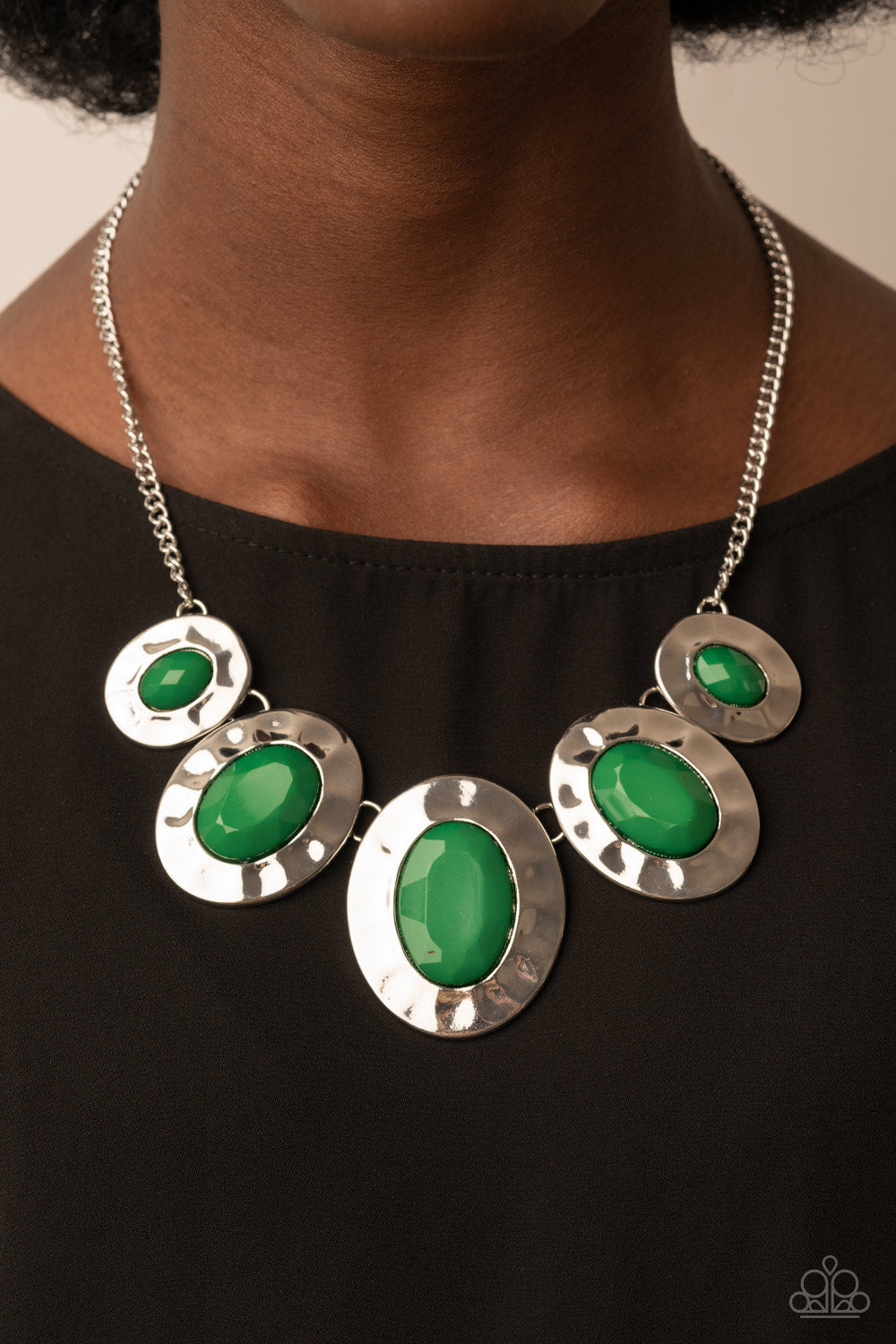 Paparazzi Accessories - Rivera Rendezvous - Green Necklaces gradually increasing in size, hammered silver oval frames are dotted with opalescent Leprechaun beads as they delicately link below the collar for a refreshing pop of color. Features an adjustable clasp closure.  Sold as one individual necklace. Includes one pair of matching earrings.