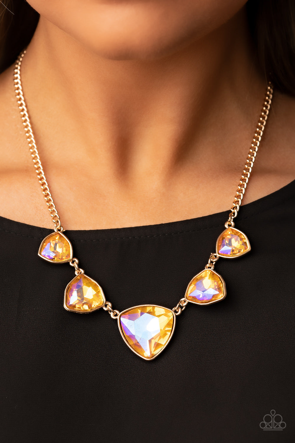 Paparazzi Cosmic Constellations - Gold Gem Necklaces encased in sleek gold fittings, an oversized collection of UV geometric gems gradually increase in size as they link below the collar for a golden statement. Features an adjustable clasp closure.  Sold as one individual necklace. Includes one pair of matching earrings.