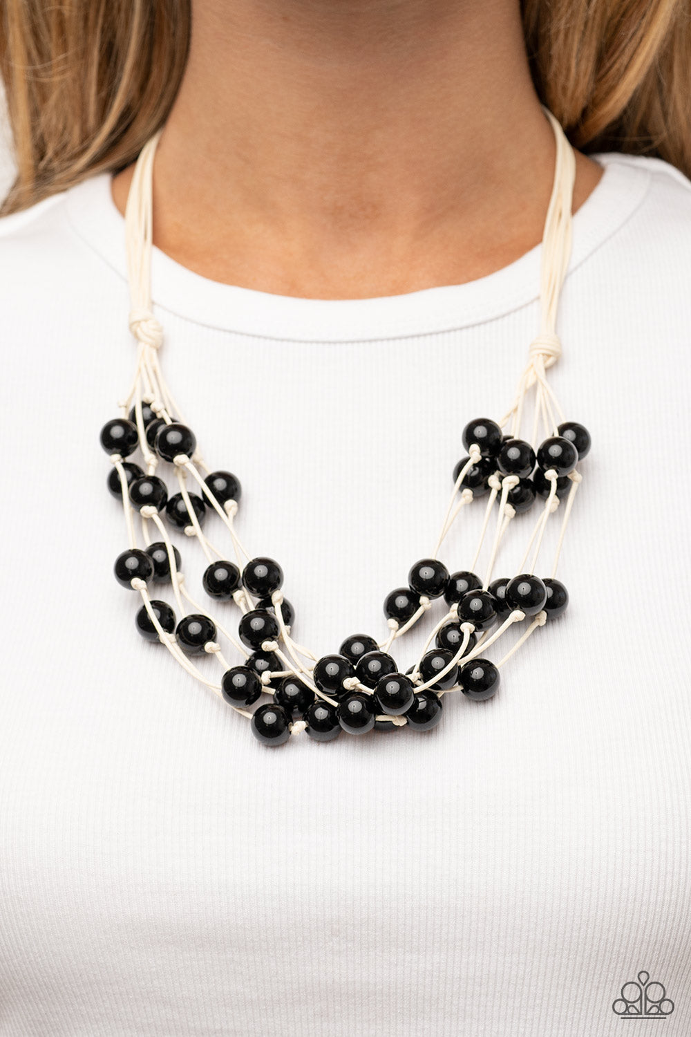 Paparazzi Accessories - Yacht Catch - Black Necklaces a collection of bubbly black beads are knotted in place along strands of white cording, resulting in boisterous layers below the collar. Features a button-loop closure.  Sold as one individual necklace. Includes one pair of matching earrings.