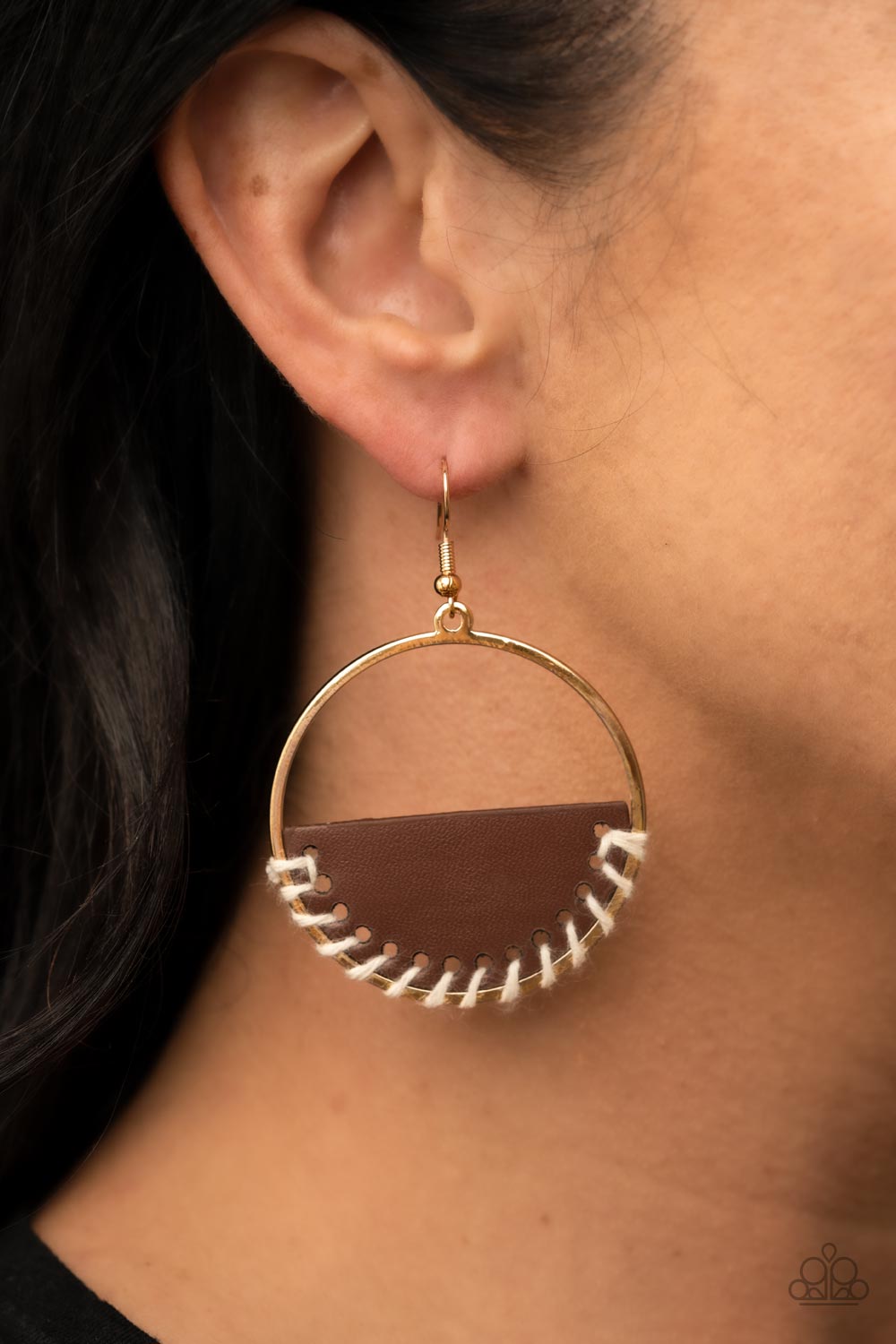 Paparazzi Accessories - Lavishly Laid Back - Brown Earrings white cording is threaded through the bottom of a half moon piece of brown leather, anchoring the earthy accent in place inside a glistening gold hoop for an earthy flair. Earring attaches to a standard fishhook fitting.  Sold as one pair of earrings.