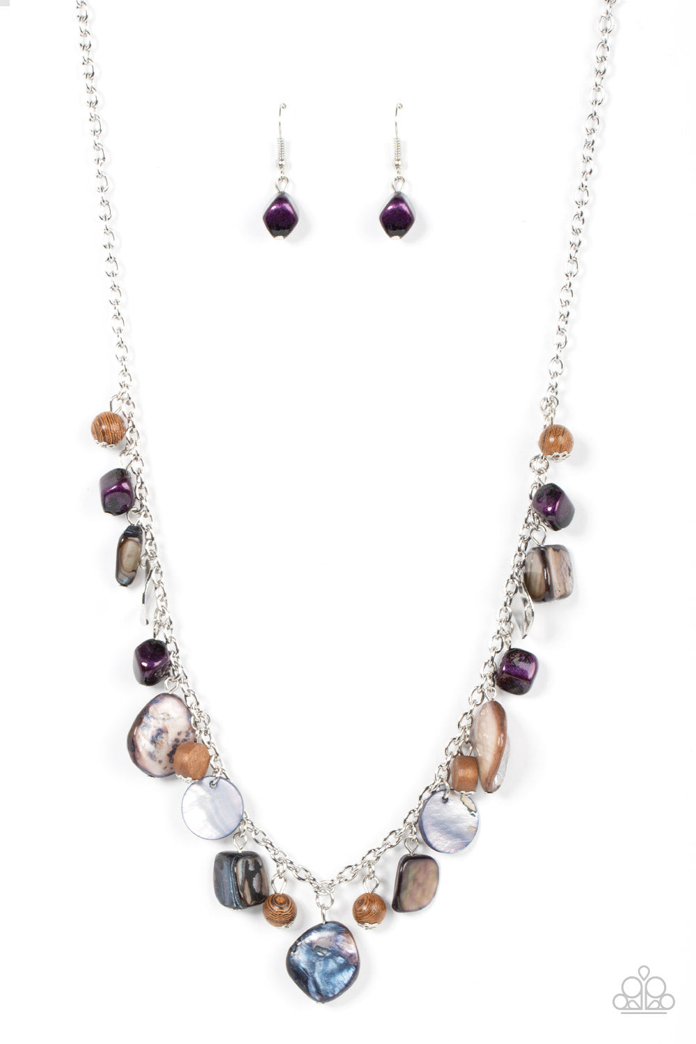 Paparazzi Accessories - Caribbean Charisma - Purple Necklaces a mismatched collection of warped silver discs, brown wooden beads, and iridescent shell-like rock accents dances from the bottom of a classic silver chain, creating a tropical sensation across the chest. Features an adjustable clasp closure.  Featured inside The Preview at GLOW!  Sold as one individual necklace. Includes one pair of matching earrings.