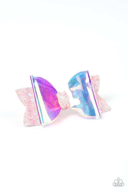 Futuristic Favorite - Multi Iridescent Hair Clip an iridescent plastic bow is layered over a glittery pink fabric cutout creating a shimmering futuristic vibe. Features a standard hair clip on the back.  Sold as one individual hair clip.