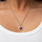 Taken With Twinkle - Red Heart Rhinestone Necklaces bordered in stacked rows of glassy white rhinestones, a fiery red heart shaped gem sparkles at the center of a dainty silver chain for a flirtatious fashion. Features an adjustable clasp closure.  Sold as one individual necklace. Includes one pair of matching earrings.