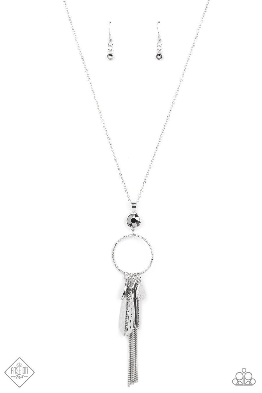 Paparazzi Tastefully Tasseled - Silver Charm Necklaces featuring both smooth and hammered finishes, dainty smoky rhinestones, and a tassel of dainty chains, a sassy collection of silver charms swings from the bottom of a brightly textured circle. A faceted hematite gem sits atop the harmoniously audacious display at the bottom of a lengthened dainty silver chain for a crowning finish. Features an adjustable clasp closure.  Sold as one individual necklace. Includes one pair of matching earrings.