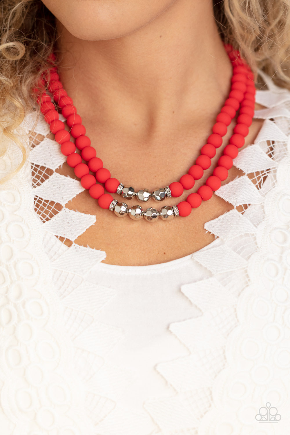 Threaded along invisible wires, matte-finished Poinciana beads give way to center sections of white rhinestone encrusted rings and faceted silver beads. The vivacious display layers below the collar, creating a summery splash of color. Sold as one individual necklace. Includes one pair of matching earrings. he wrist. White rhinestone encrusted rings flank a trio of faceted silver beads along a stretchy row of matte-finished Poinciana beads, creating a summery splash of color around the wrist.