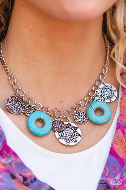 Paparazzi Accessories Western Zen - Blue Stone Convention Necklaces a collection of silver discs, embellished with intricate mandala-like designs, dances along a thick silver chain, with a pair of polished turquoise stone rings adding a pop of color to the rustic design. Features an adjustable clasp closure.  Sold as one individual necklace. Includes one pair of matching earrings.  2022 GLOW Convention Necklaces 