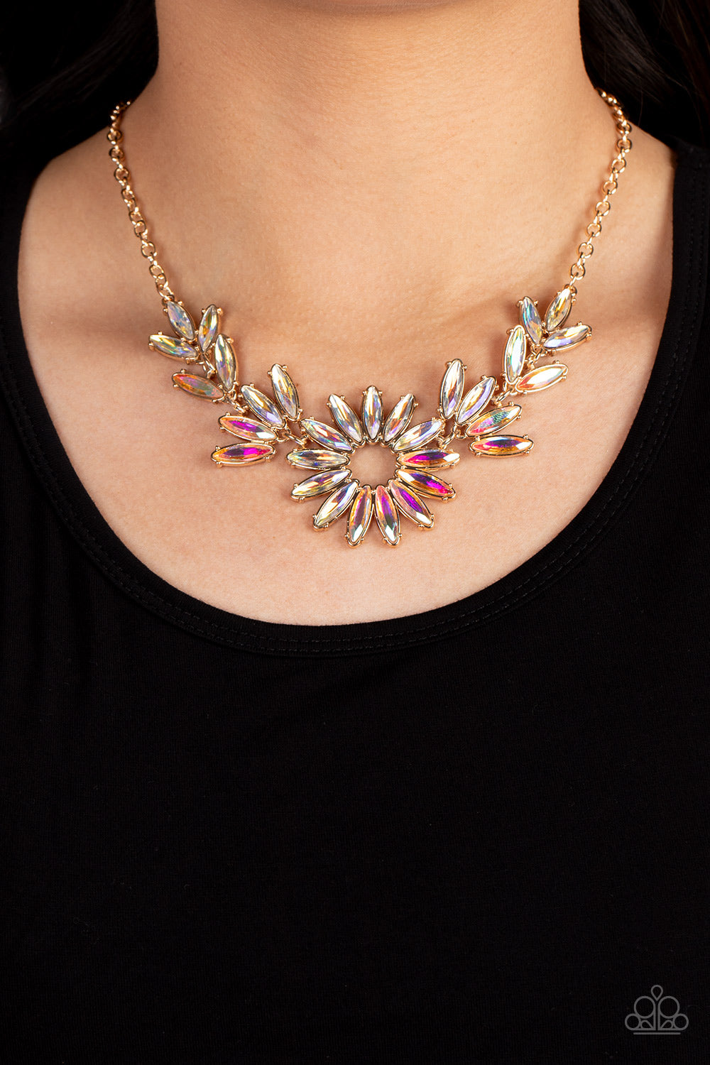 Paparazzi Accessories Celestial Cruise - Gold Iridescent Necklaces featuring oblong marquise cuts, a collection of iridescent gems join into leafy gold frames below the collar. Radiating with the same iridescent intensity, even more stellar rhinestones fan out into a circular focal point, resulting in a celestial centerpiece. Features an adjustable clasp closure. Due to its prismatic palette, color may vary.  Sold as one individual necklace. Includes one pair of matching earrings.