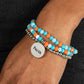 Embellished with silver and defaced beads in varying shades of blue and orange, three bracelets are threaded along elastic stretchy bands, for a fashionable stack across the wrist. Falling from one of the varying blue and orange bangles, a silver disc, with a hammered sheen, features the word "Faith," creating a simplistic collision of color and energy for a light-hearted finish.  Sold as one individual bracelet.