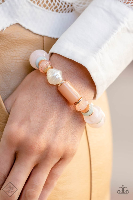 Gold accents and discs combine with a collection of solid, cloudy, and crackle beads in varying sizes and colors to create a modern statement that wraps around the wrist on a stretchy band. The shades of pastel green and soft peach create a fresh and subdued palette, as asymmetrical white pearl beads introduce a hint of refinement.  Sold as one individual bracelet.