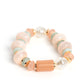 Gold accents and discs combine with a collection of solid, cloudy, and crackle beads in varying sizes and colors to create a modern statement that wraps around the wrist on a stretchy band. The shades of pastel green and soft peach create a fresh and subdued palette, as asymmetrical white pearl beads introduce a hint of refinement.  Sold as one individual bracelet.