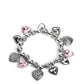Paparazzi Accessories - Charming Crush - Pink Heart Bracelets decorative silver filigree, silver-studded, and pink gem heart charms swing from a collection of shiny silver beads, and silver beads with a dot motif. Threaded along an elastic stretchy band, the charming bracelet creates a timeless romantic centerpiece around the wrist.  Sold as one individual bracelet.