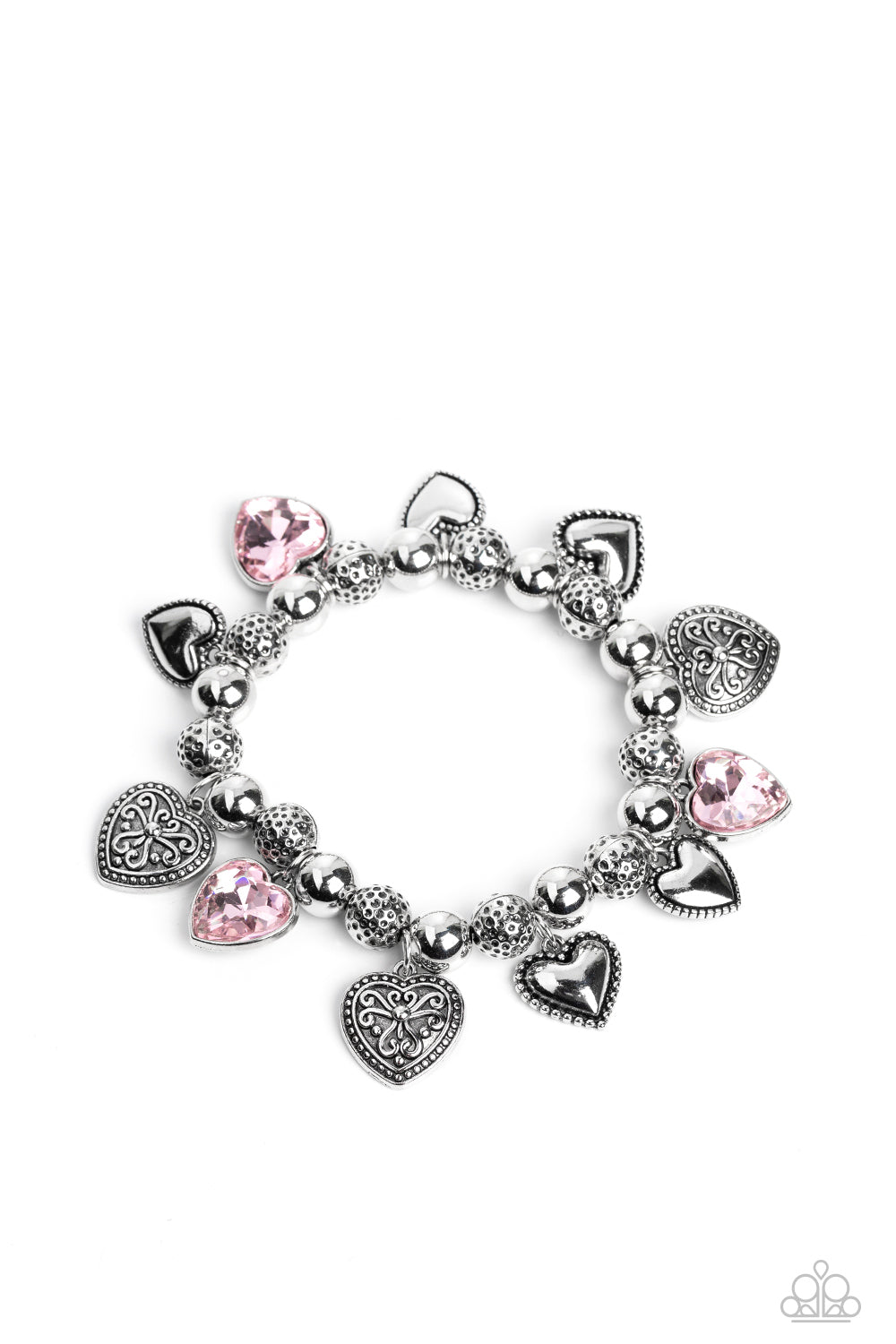 Paparazzi Accessories - Charming Crush - Pink Heart Bracelets decorative silver filigree, silver-studded, and pink gem heart charms swing from a collection of shiny silver beads, and silver beads with a dot motif. Threaded along an elastic stretchy band, the charming bracelet creates a timeless romantic centerpiece around the wrist.  Sold as one individual bracelet.