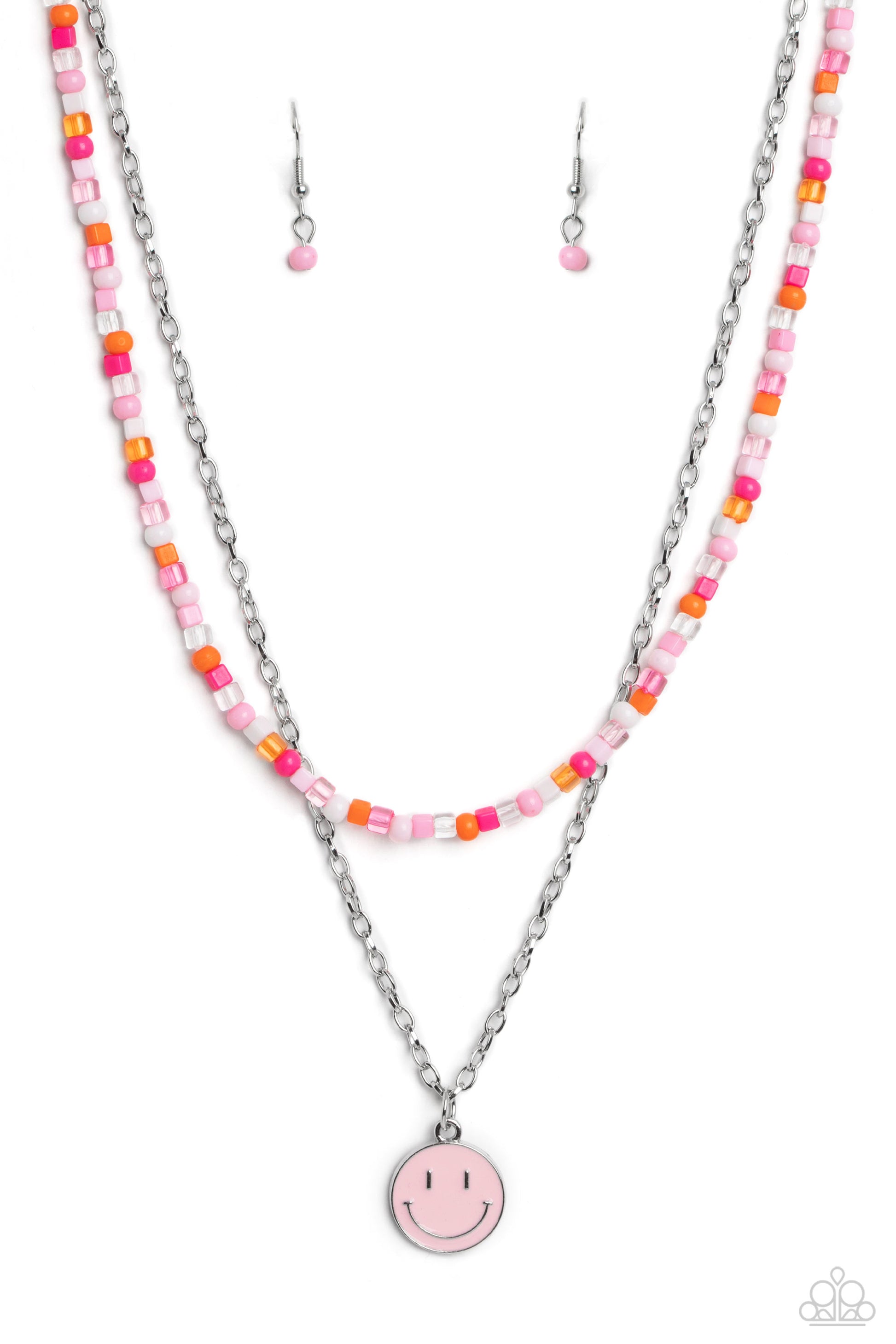 Paparazzi Accessories - High School Reunion - Pink Smiley Necklace Gliding from a dainty, silver chain, a smiley face pendant stands out against a pink backdrop. Completing the charismatic ensemble, a collection of seed beads in shades of light pink, white, pink, orange, and hot pink create bright pops of color around the neckline for a youthful finish. Features an adjustable clasp closure.  Sold as one individual necklace. Includes one pair of matching earrings.