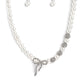 strand of classic white pearls coalesces down the neckline in a feminine display. Airy silver spheres, adorned in sparkling white rhinestones, are effortlessly sprinkled among the sea of pearls on one side, infusing the design with capricious shimmer. Then in the perfect finishing touch, a ribbon of silver, adorned in tiny white pearls and sparkling white rhinestones, loops into a bow at the bottom of the design. Features an adjustable clasp closure.