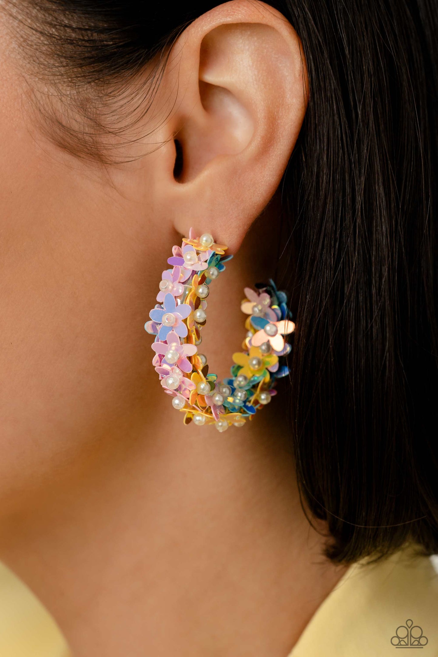 floral explosion, encompassing the entirety of a thick silver hoop, features reflective light blue, pink, and yellow flowers dotted with dainty pearl centers for a dreamy, whimsicality below the ear. Earring attaches to a standard post fitting. Hoop measures approximately 1 1/2" in diameter.  Sold as one pair of hoop earrings.