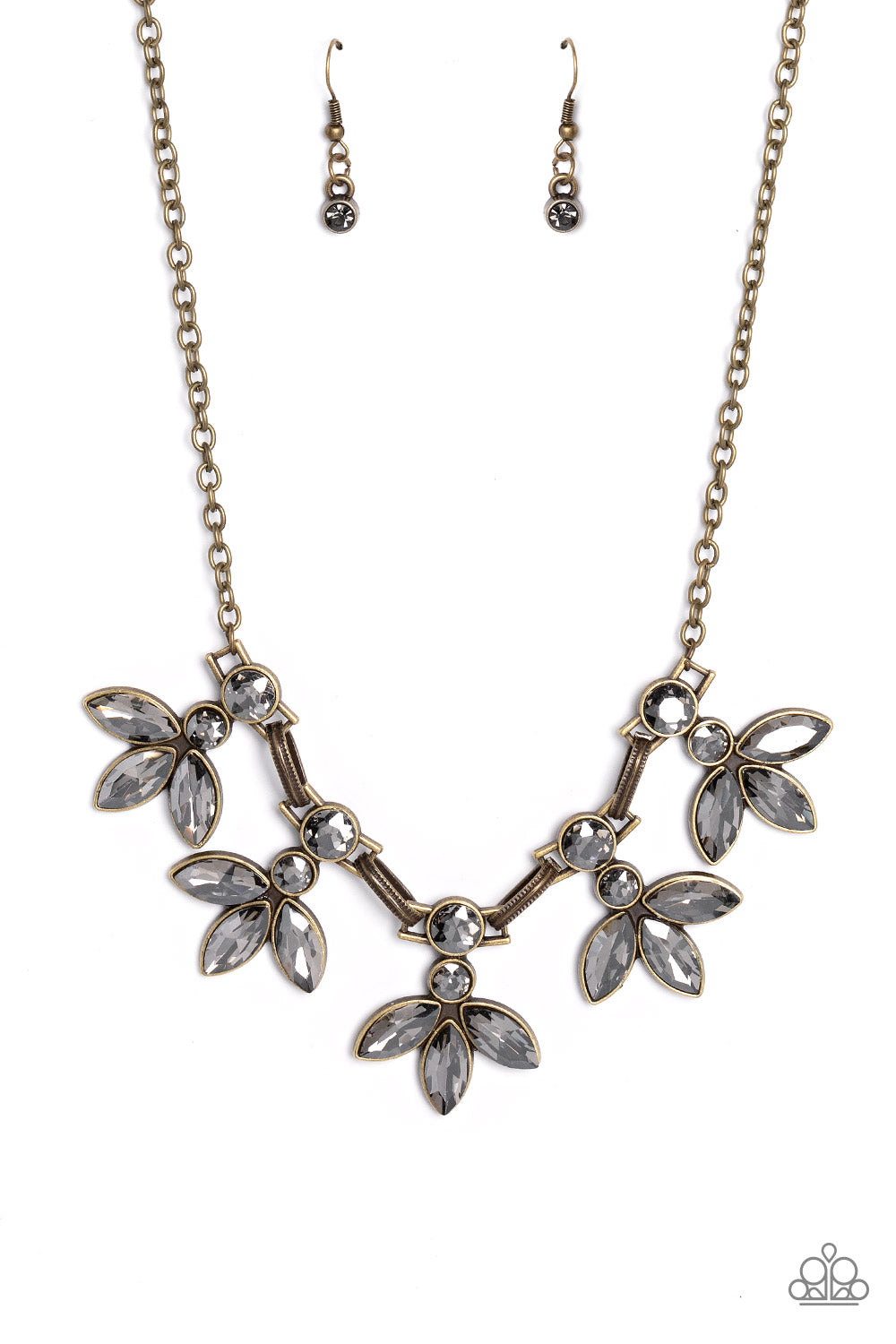 Paparazzi Accessories - Dauntlessly Debonair - Brass EMP 2023 Brass Necklaces featuring smoldering marquise style cuts, oversized smoky gems fan out from an interconnected, circular smoky rhinestone display. Separating the dauntless florals, airy brass ovals, stamped with a dot motif, create additional eye-catching sheen. Features an adjustable clasp closure.  Sold as one individual necklace. Includes one pair of matching earrings.