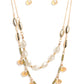 Two strands of dainty gold chain are adorned in a collection of white opaque beads, faceted glass beads, and gold accents, culminating in a layered design rich with vintage character. The glassy beads that swing along the lower chain feature a subtle reflective surface in a cozy peach glow, complementing the opaque beading that lines the chain above, with tiny gold and olive green accents sprinkled throughout the piece in a rustic finish. Features an adjustable clasp closure.