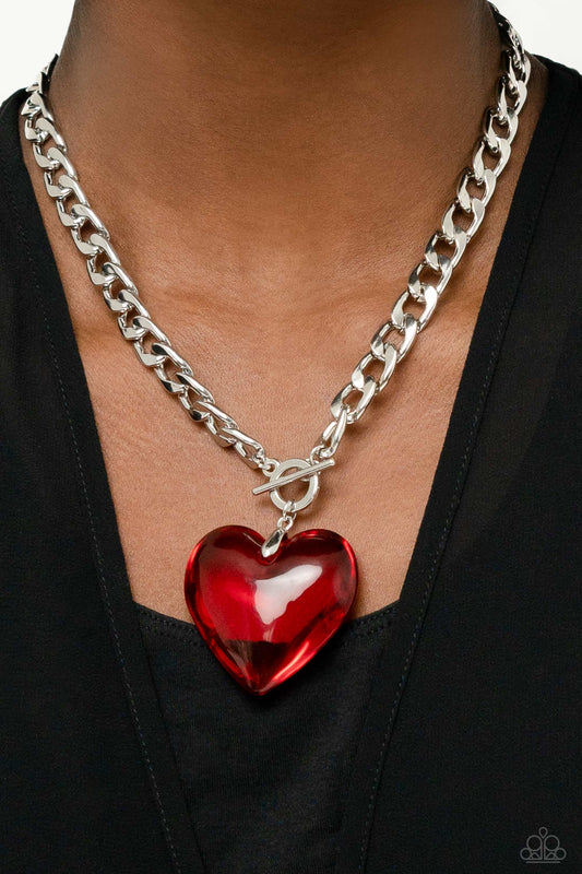Featuring a glossy finish, an oversized, rich, red heart gem swings from the bottom of a thick silver curb chain below the collar for a romantic declaration. Features a toggle closure.  Sold as one individual necklace. Includes one pair of matching earrings.