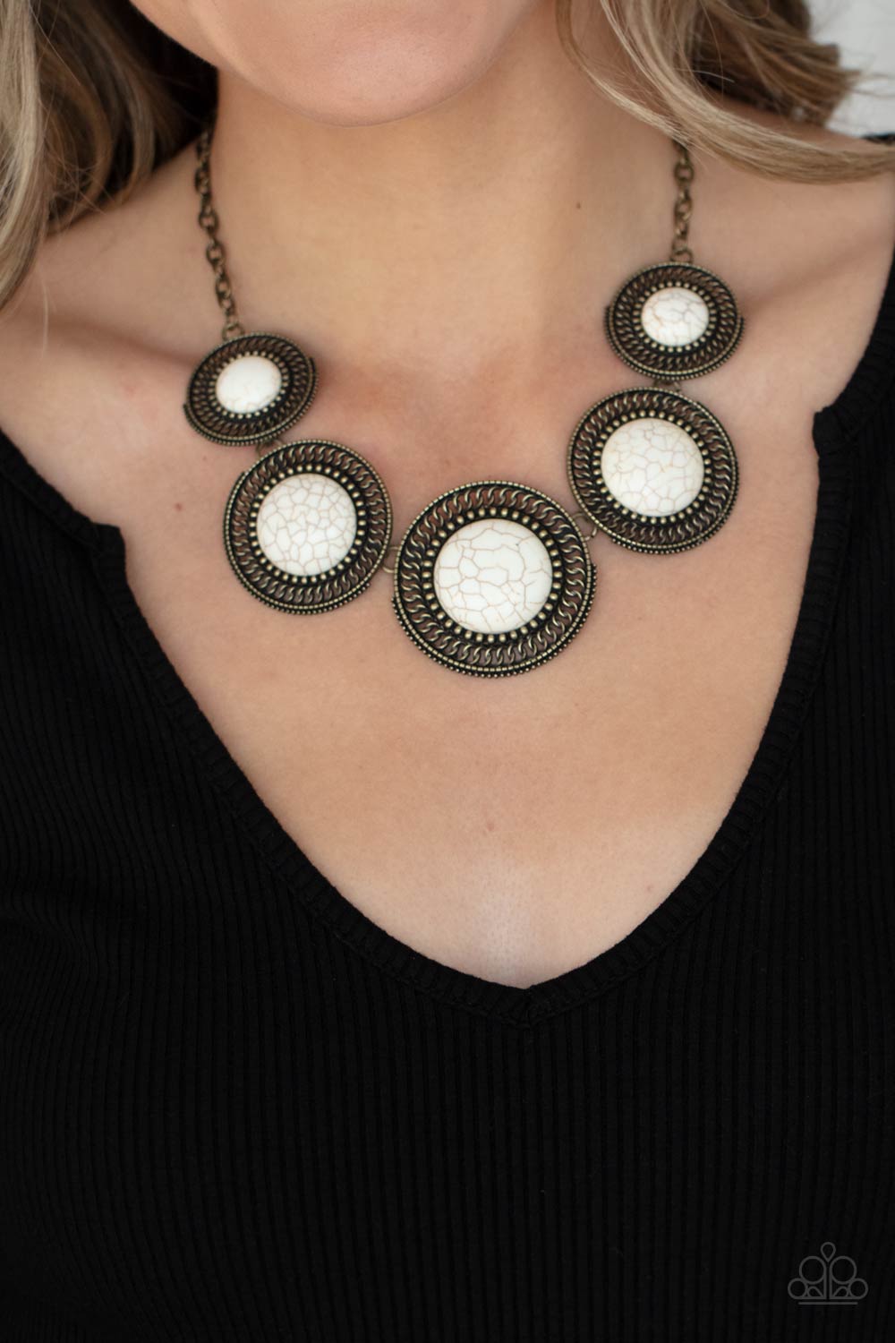 She Went West - Brass Frame White Stone Necklaces earthy white stones, pressed into round antiqued brass frames featuring dot and interlinking loop motifs, create a dramatically rustic statement as they link across the collar. Features an adjustable clasp closure.  Sold as one individual necklace. Includes one pair of matching earrings.  Paparazzi Jewelry is lead and nickel free so it's perfect for sensitive skin too!