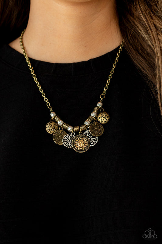To Coin a Phrase - Brass Necklaces an antiqued collection of brass coin-like discs, silver vine-like frames, and hammered brass frames alternate with silver beads and ornate brass accents along the bottom of a classic brass chain. Dotted with golden topaz rhinestones, a sparkly frame adorns the center of the mismatched frames, adding a hint of sparkle to the rustic fringe. Paparazzi Jewelry is lead  and nickel free.